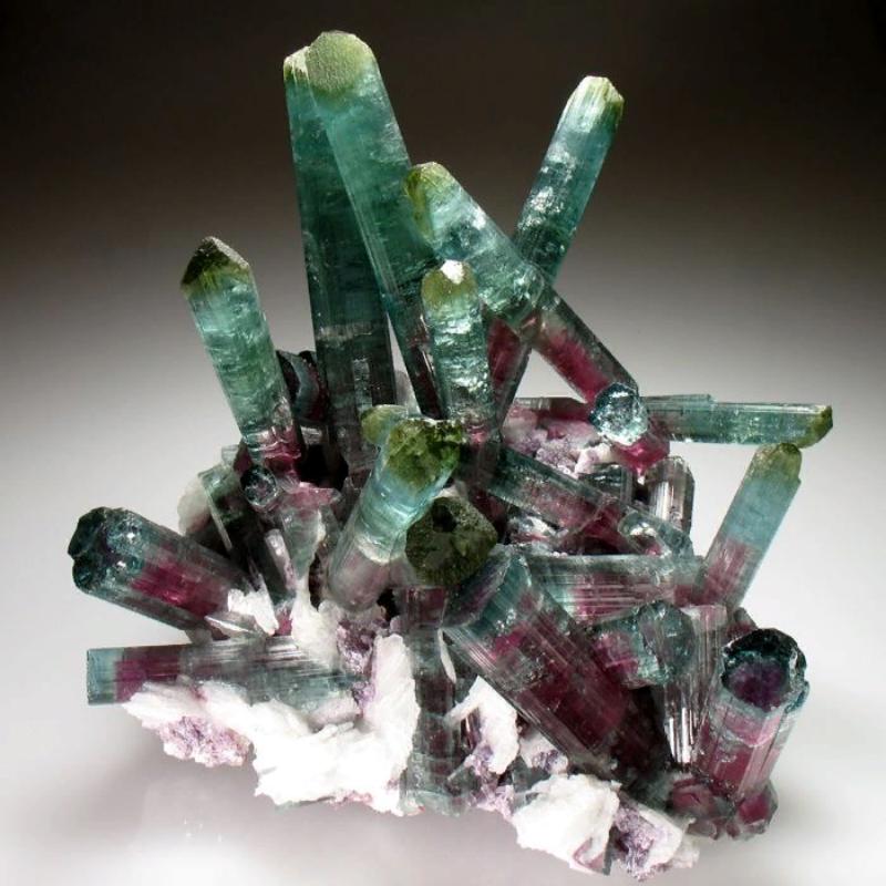 Розово зеленый камень. Хамелеонит турмалин. Турмалин-дравит минерал. Самоцветы камни турмалин. Эльбаит минерал.